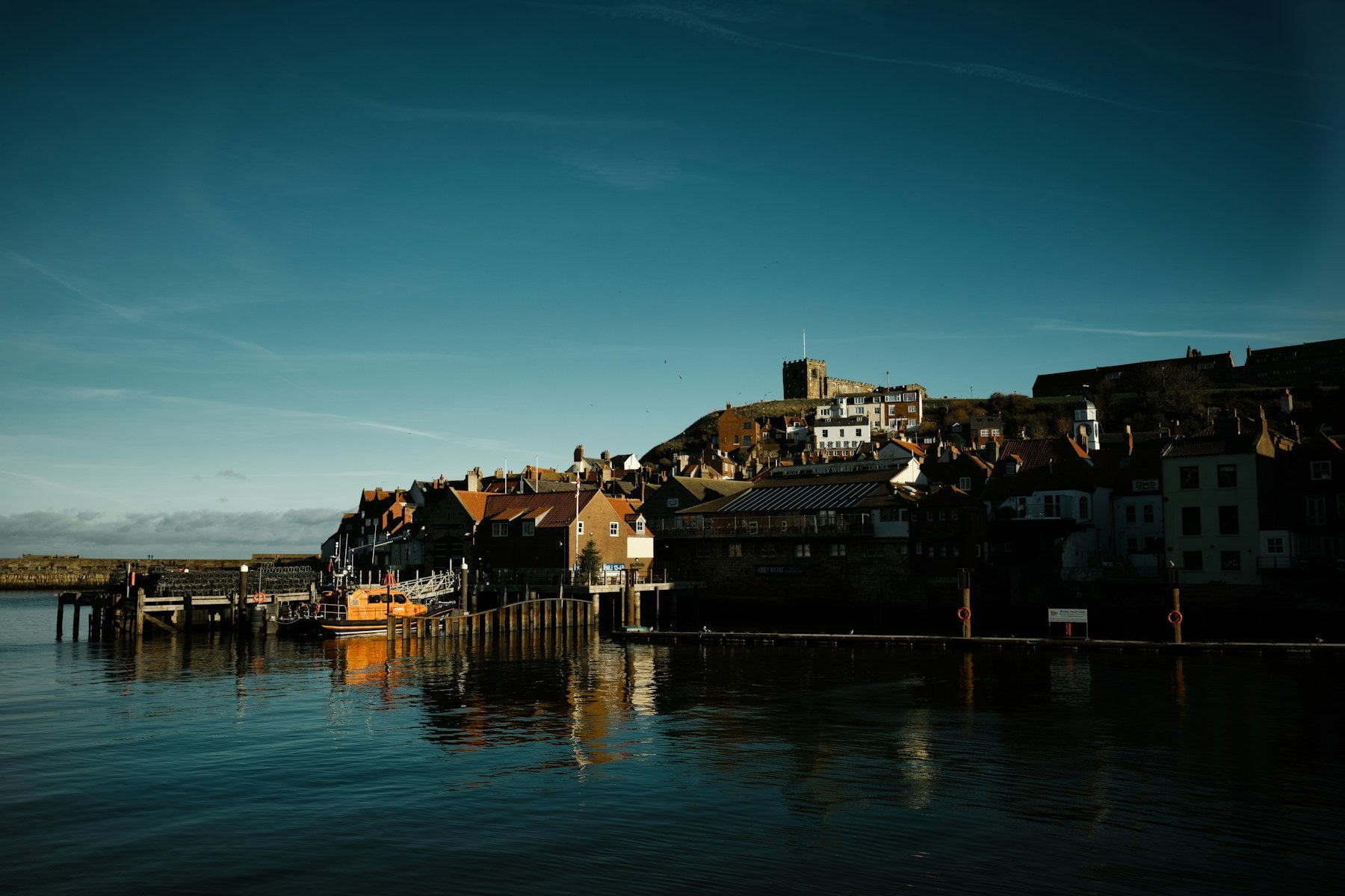 Whitby’s harbour and hillside cottages on a bright day