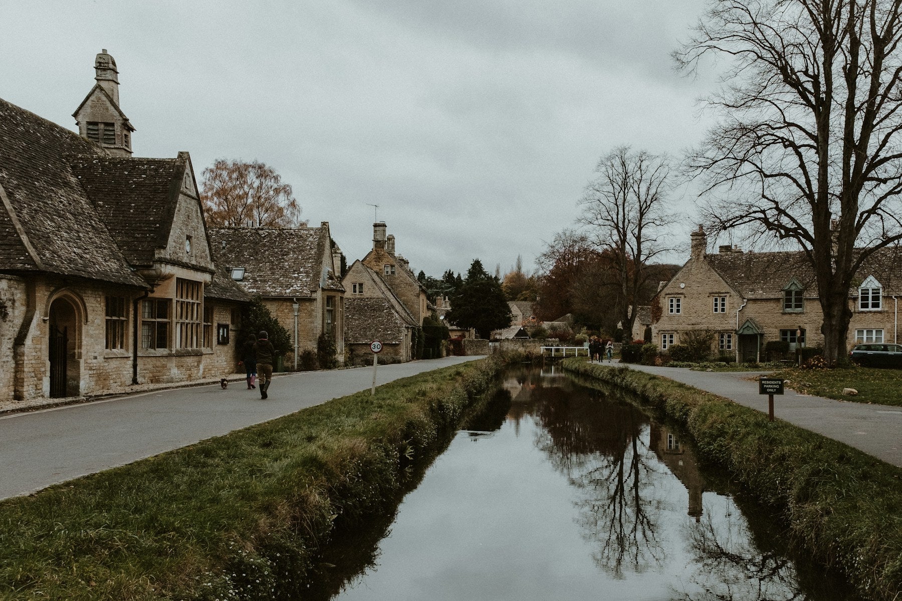 A peaceful river winding through a Cotswold village